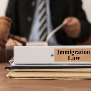 Immigration law file on judge's desk with gavel - Driggs Immigration Law